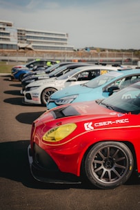 A sleek set of remote-controlled cars lined up on a race track, gleaming under natural light to emphasize their polished surfaces.