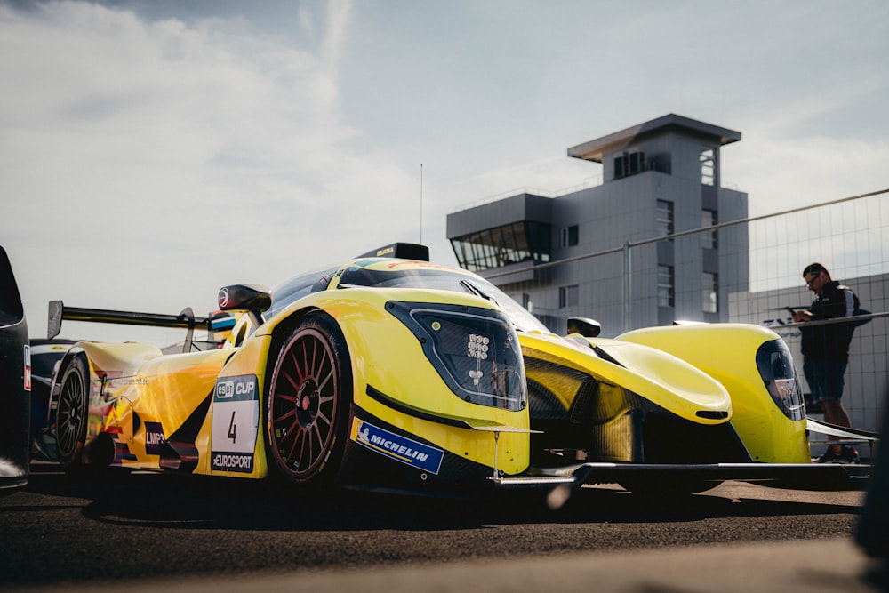 a yellow race car is parked on the street