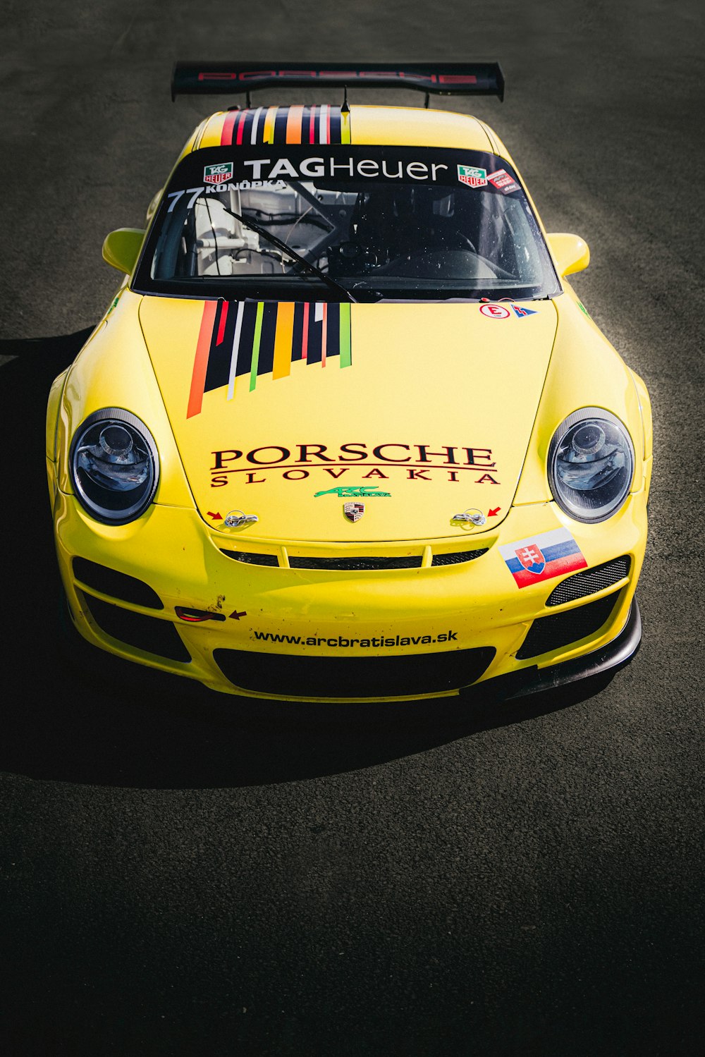 a yellow porsche racing car on a race track