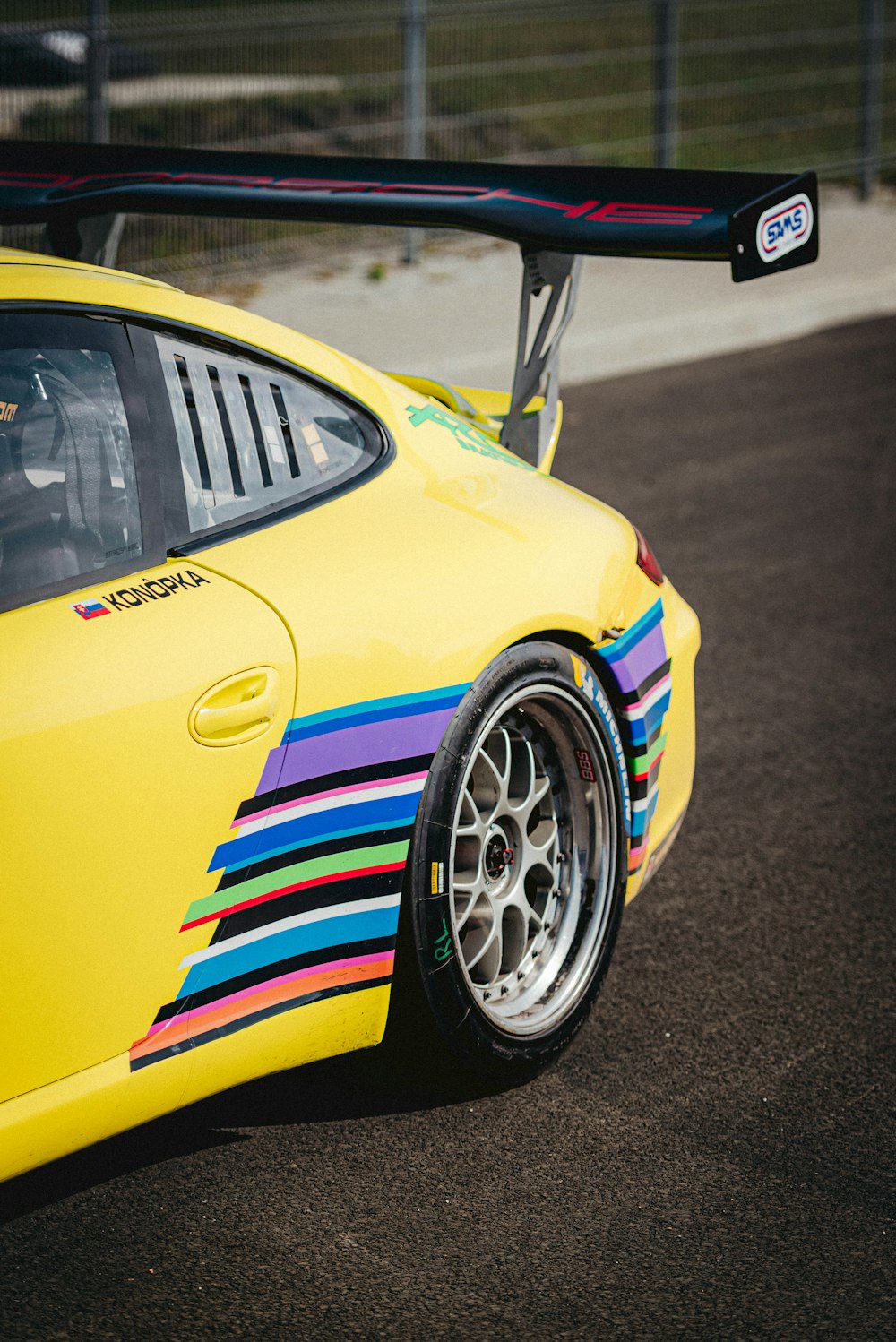 a yellow sports car with colorful stripes painted on it