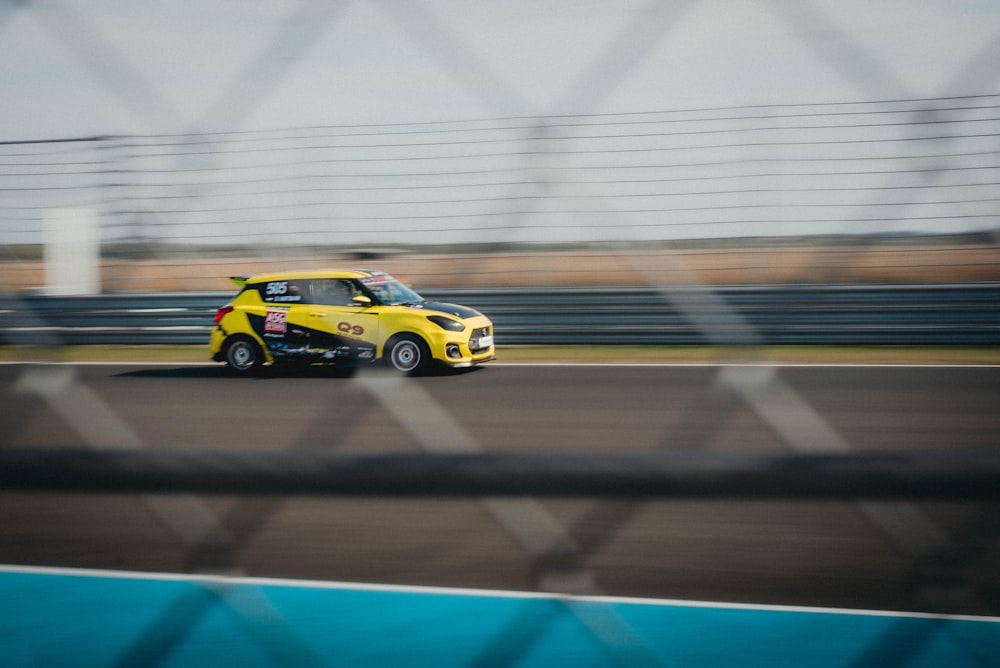 a yellow car driving down a race track