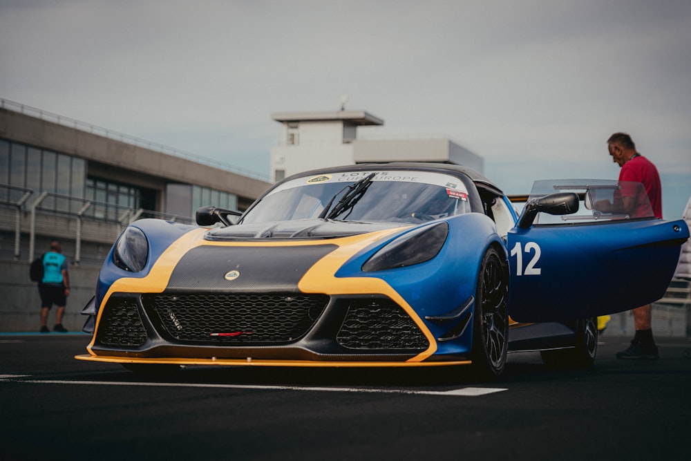 a blue and yellow sports car parked in a parking lot