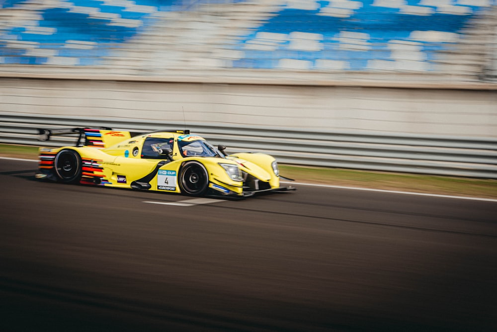 a yellow race car driving down a race track