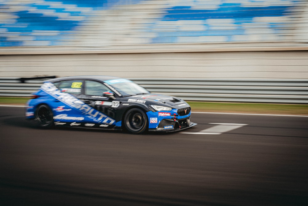 a blue car driving down a race track