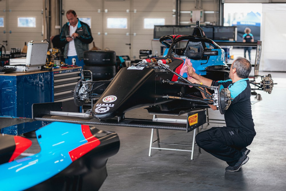 a man working on a race car in a garage