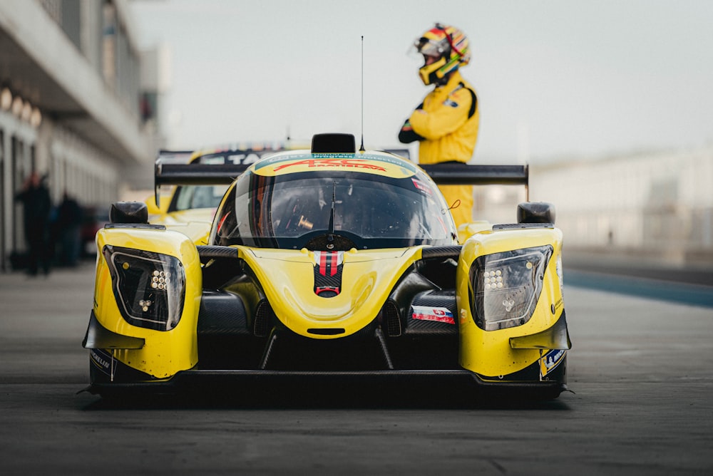 une voiture de course jaune roulant sur une piste de course