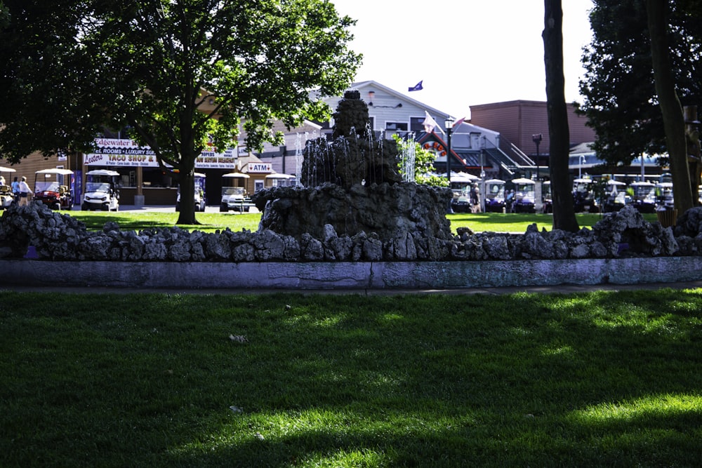 a stone fountain in a park with trees in the background