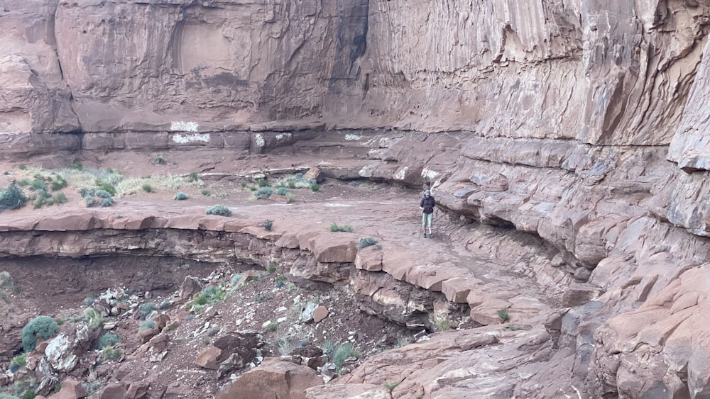 a man standing on top of a cliff next to a cliff