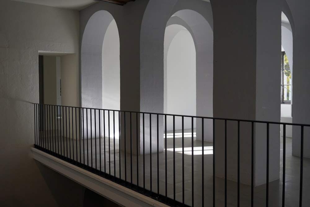 an empty room with arches and a balcony