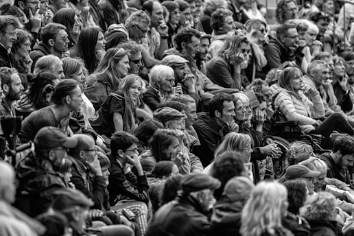 A vibrant group of diverse people watching a television together, smiling and enjoying the moment.
