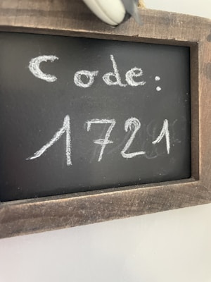 A small chalkboard with a rustic wooden frame displays the word 'code:' followed by the number '1721' written in white chalk.