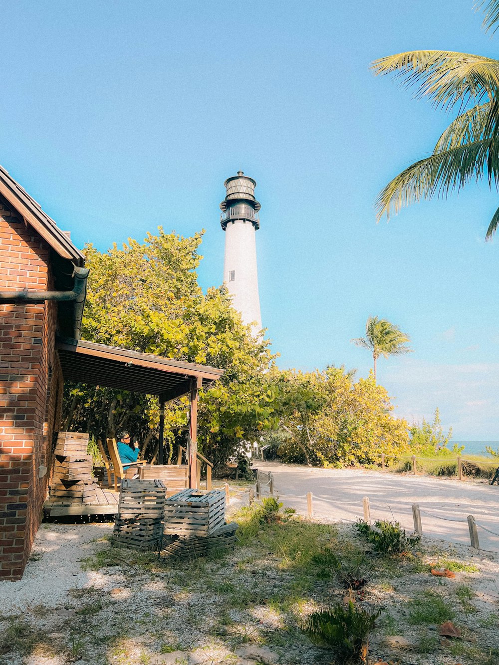 a light house sitting next to a palm tree