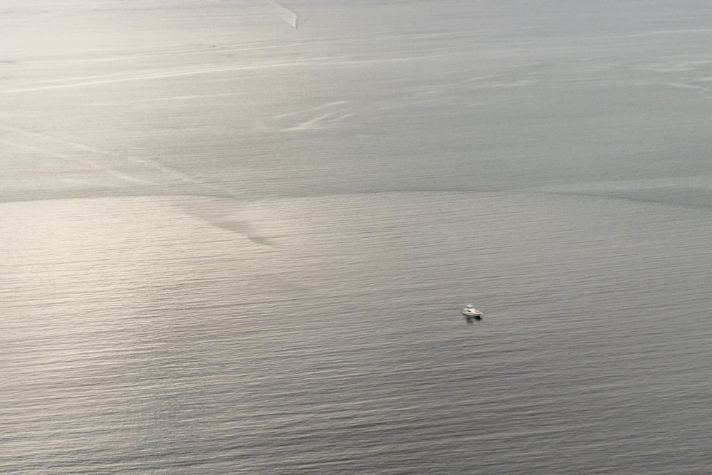 a small boat floating on top of a large body of water