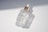 Close-up of a clear glass serum bottle with a dropper resting on soft beige linen.