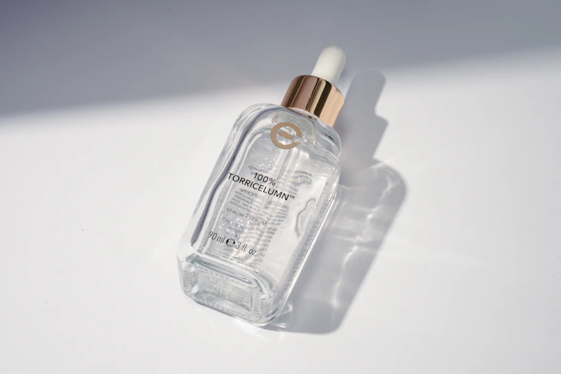 Close-up of a sleek serum bottle with droplets highlighting its purity and texture.