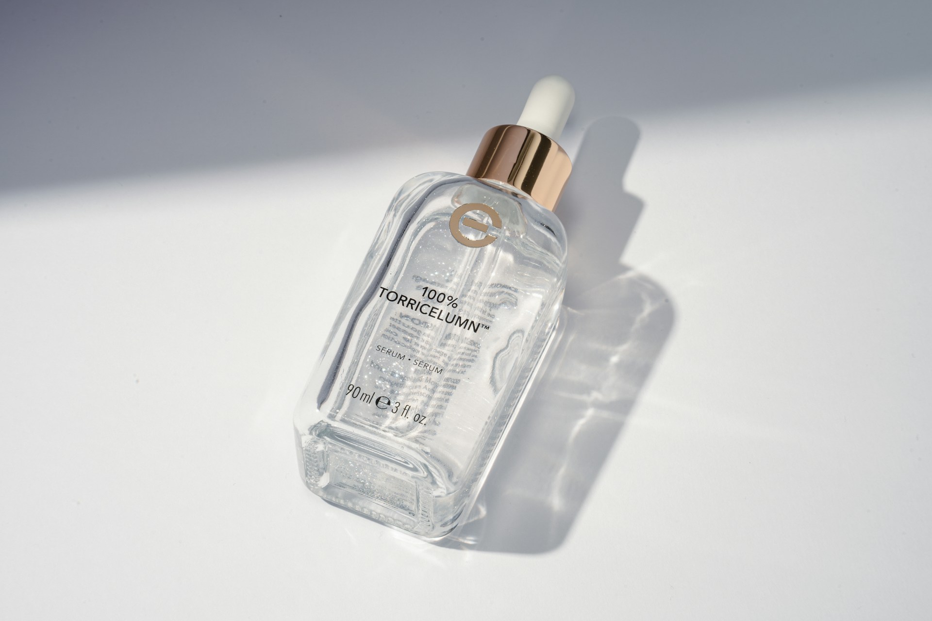 Close-up of a sleek serum bottle with a dropper, softly lit to highlight the clear liquid inside.