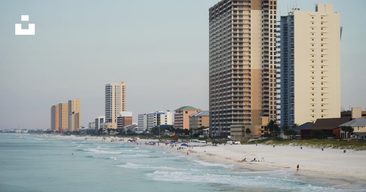 A view of a beach with tall buildings in the background photo – Free