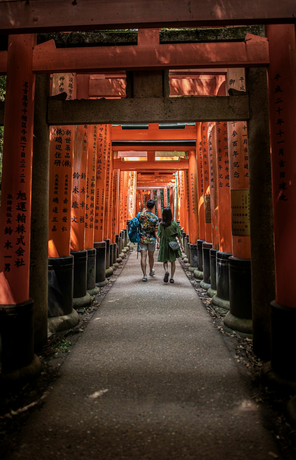 a couple of people that are walking under a bridge