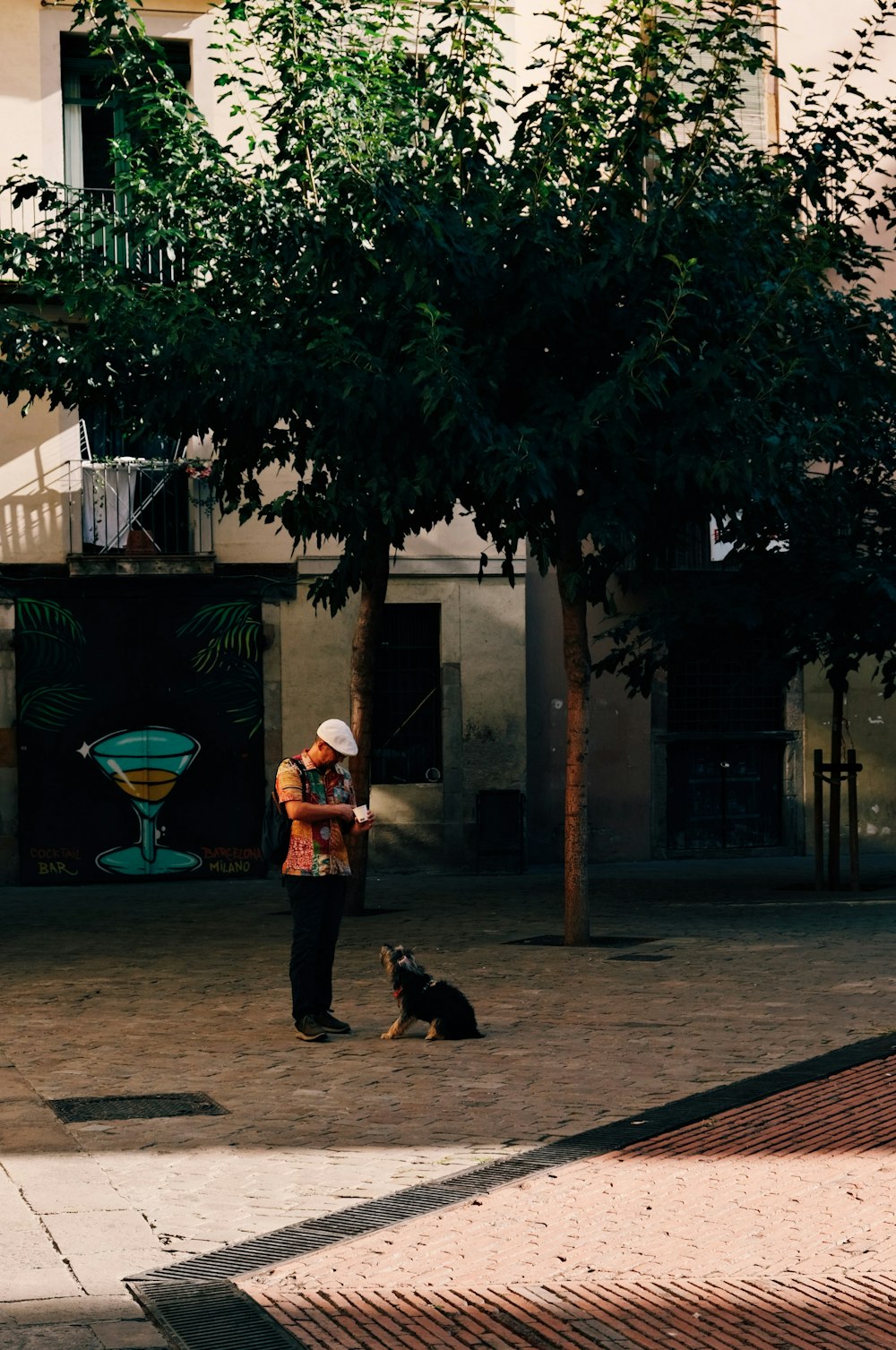 a man standing next to a dog on a sidewalk