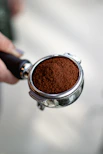 a person holding a cup of ground coffee