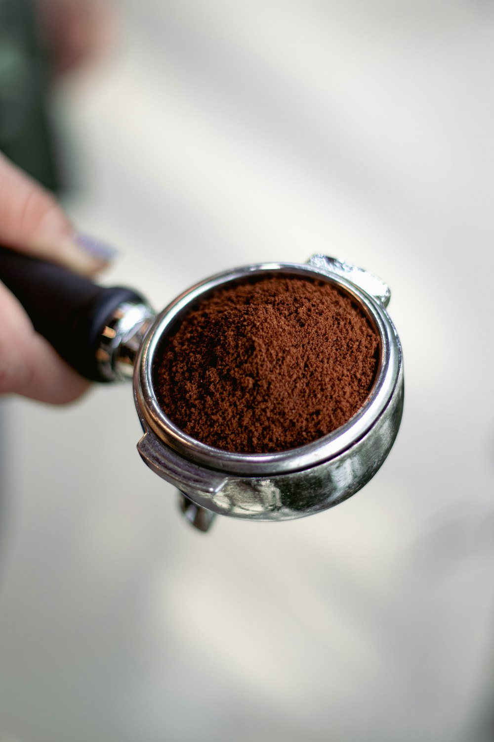 a person holding a cup of ground coffee