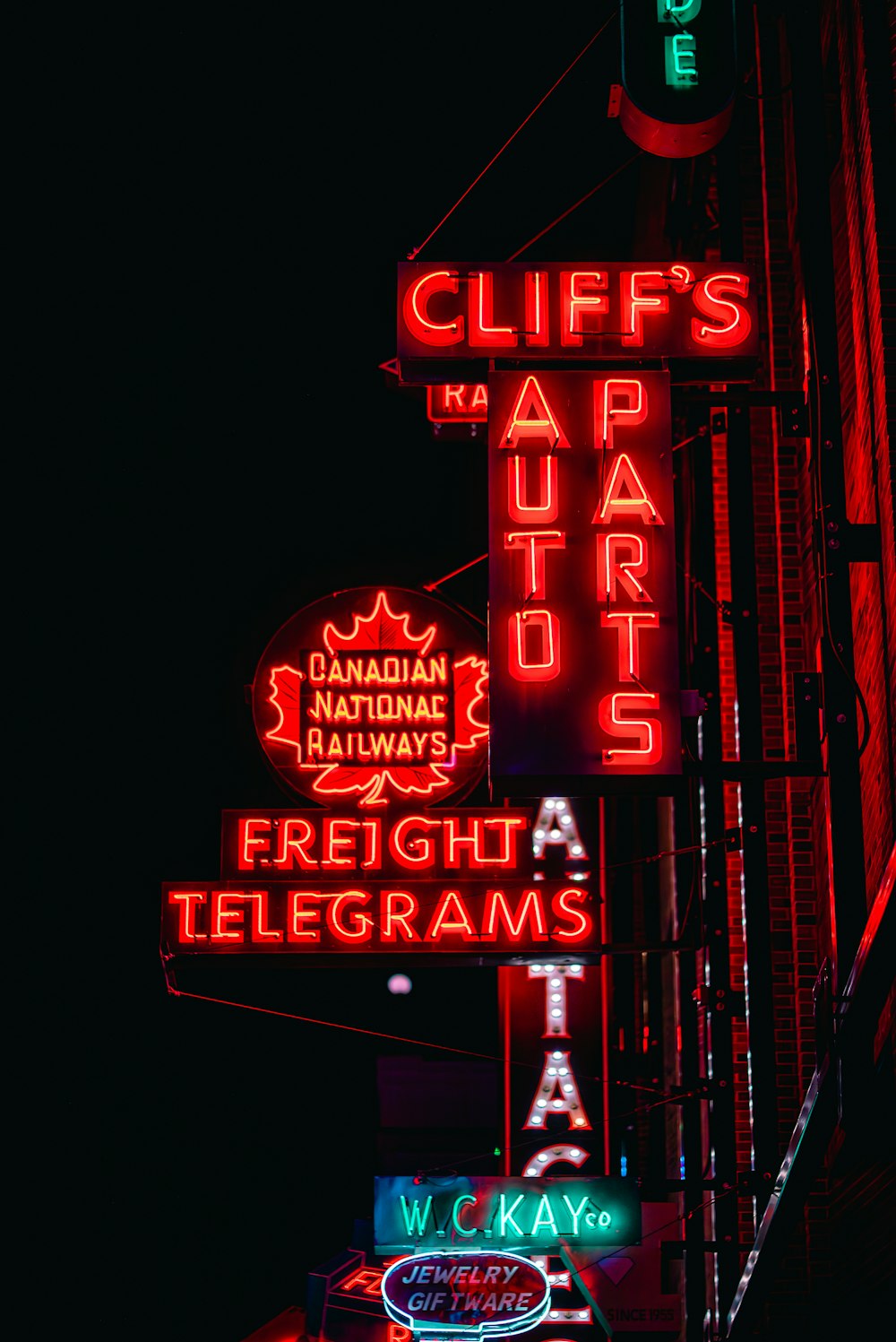 a bunch of neon signs on the side of a building