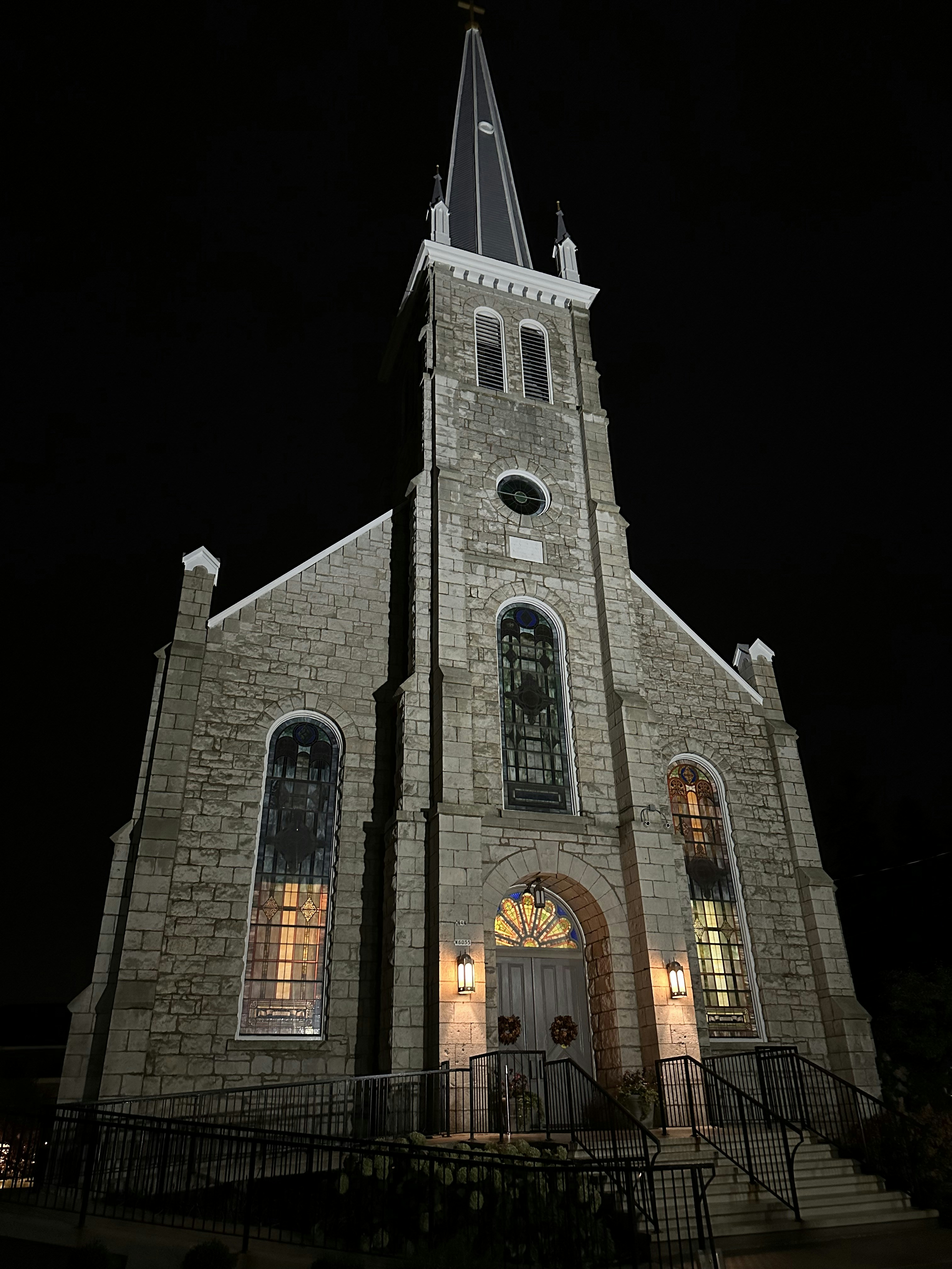 a church with a steeple and a clock tower at night
