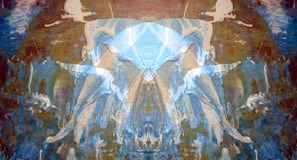 An abstract composition featuring symmetrical patterns resembling a Rorschach test. The image is dominated by hues of blue and brown, with fluid, wave-like shapes. The patterns evoke a sense of movement and depth, possibly resembling ethereal figures or forms.