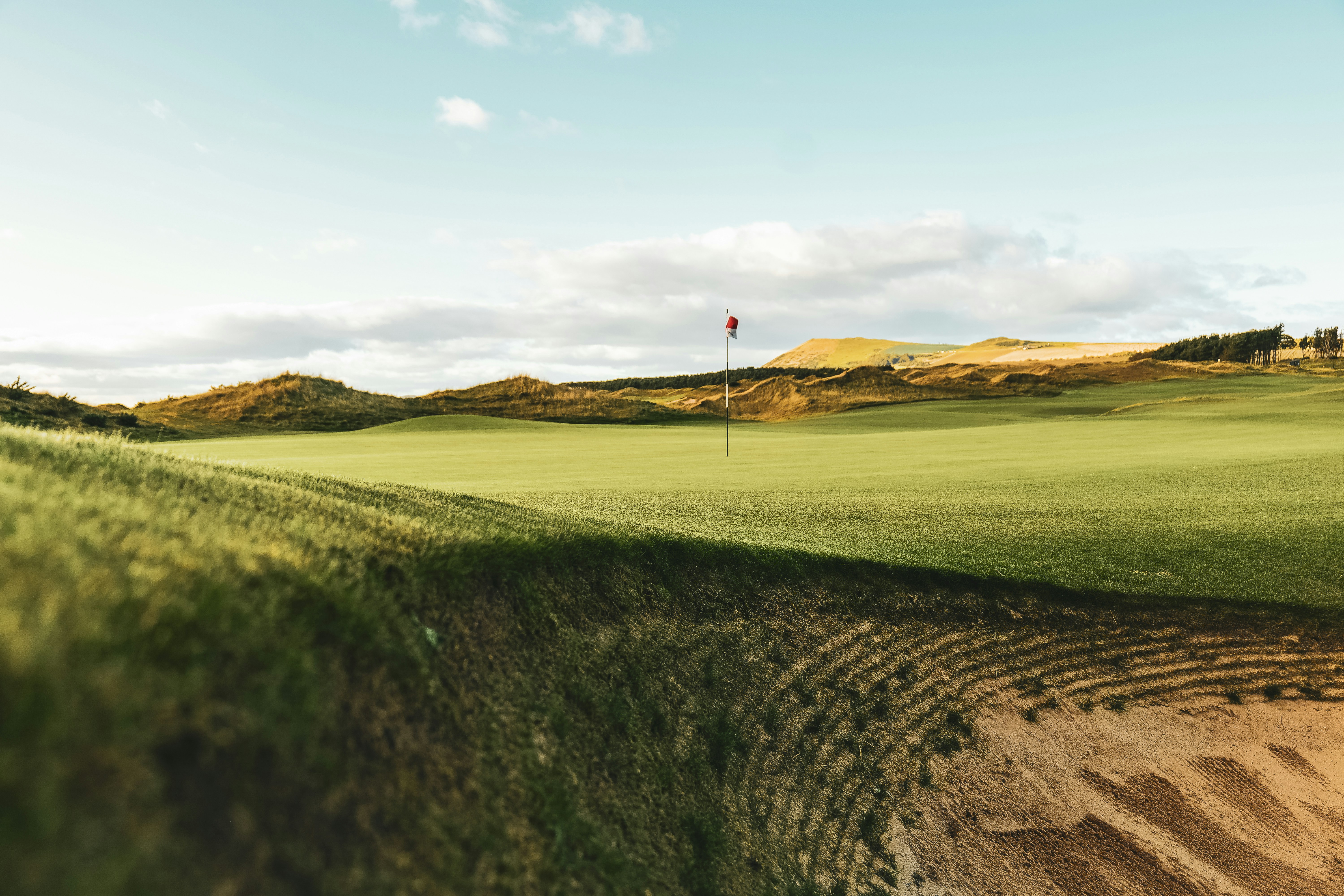 A view of a golf course from a distance photo Free Dumbarnie golf links Image on Unsplash