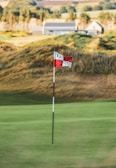 a red and white flag on a golf course