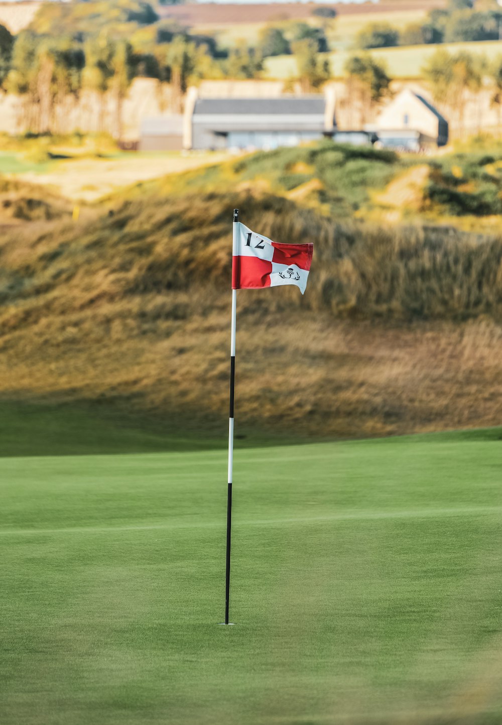 a red and white flag on a golf course
