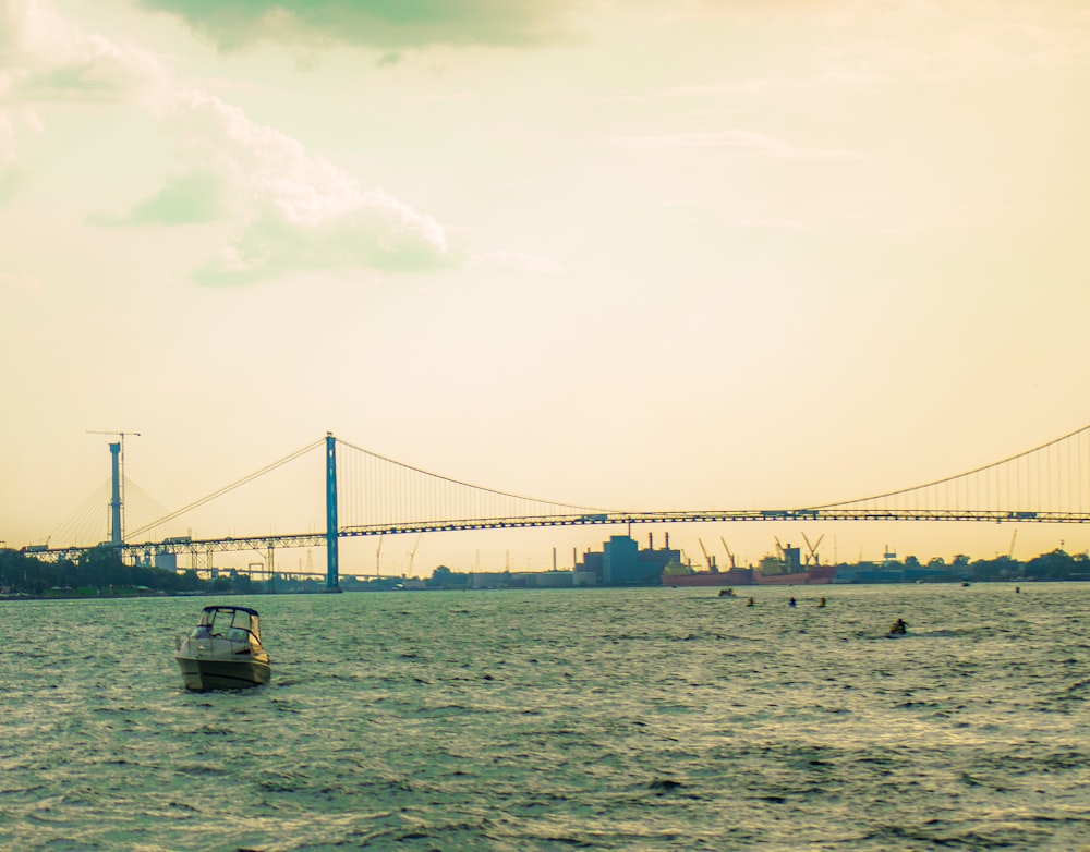 a boat in the water with a bridge in the background