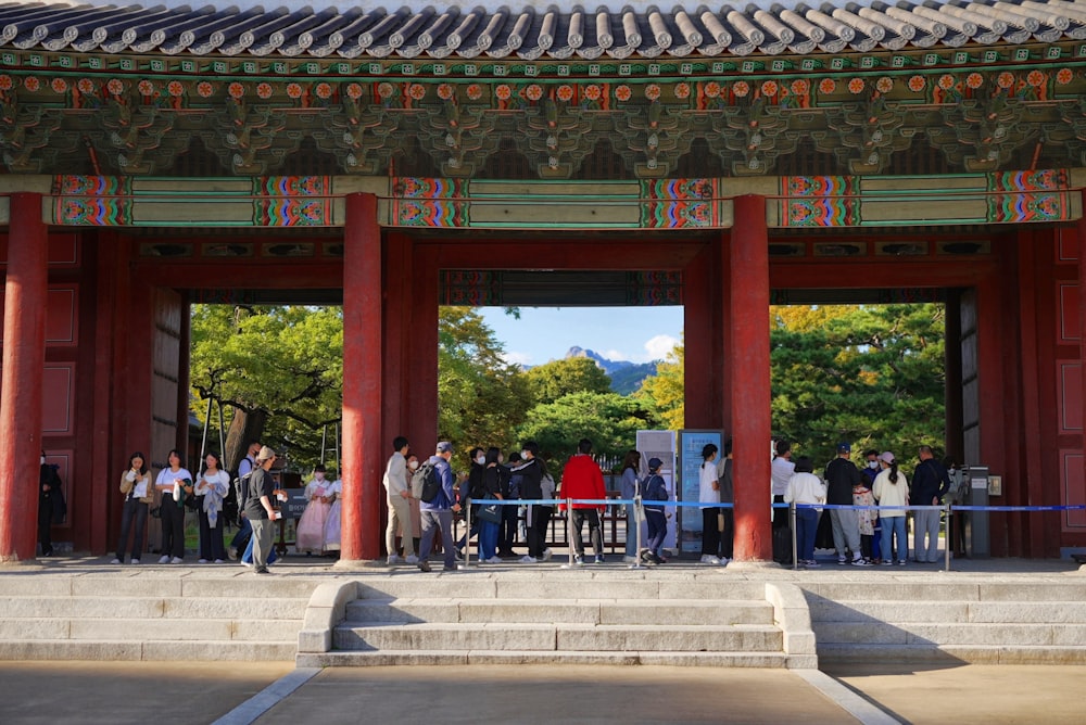 a group of people standing in front of a red building