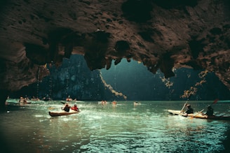 Ha Long Bay's Limestone Karsts a group of people in canoes paddling through a cave