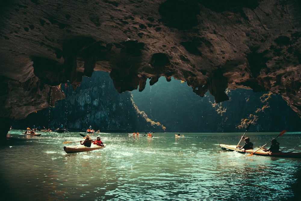 a group of people in canoes paddling through a cave