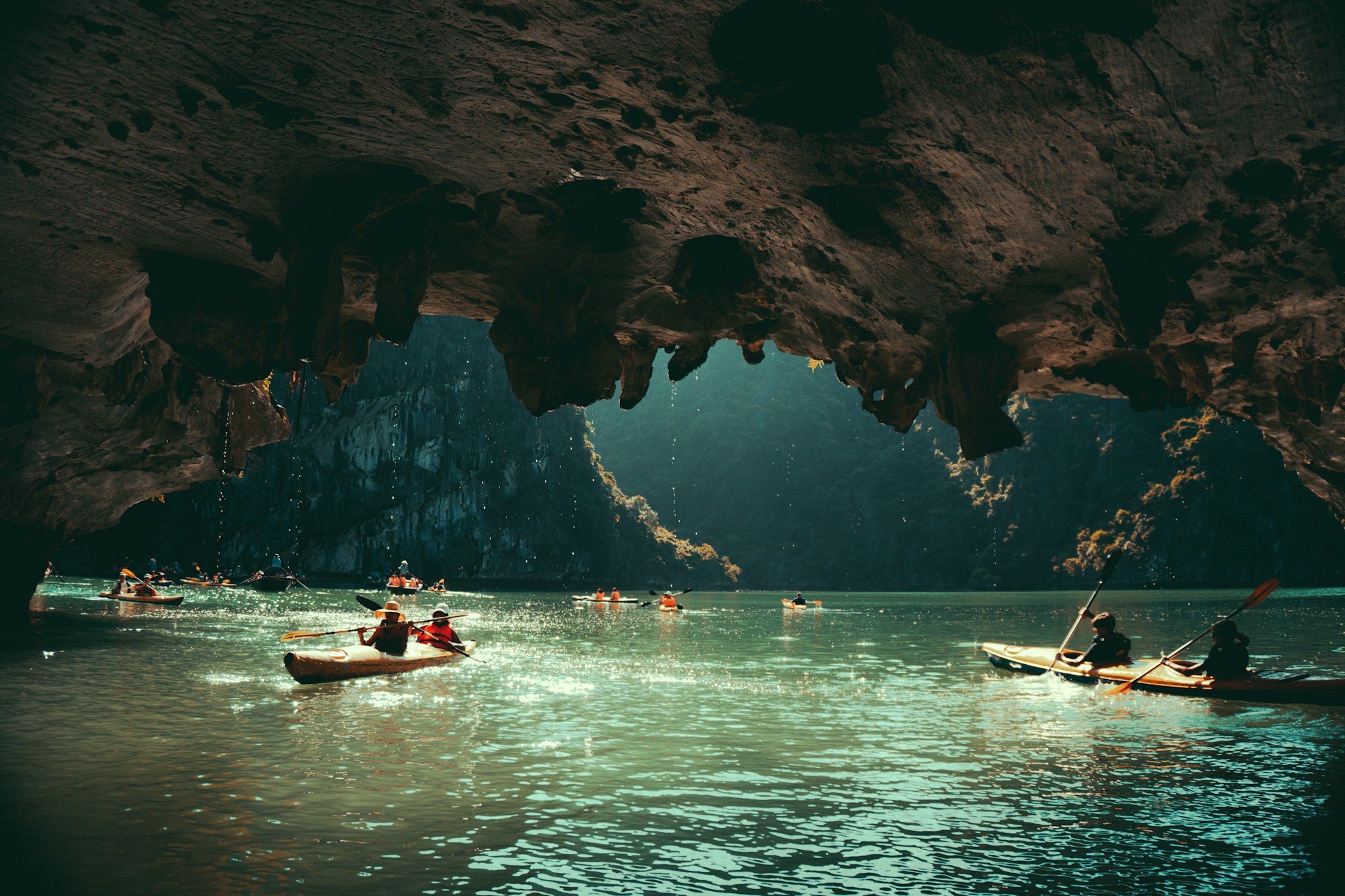 a group of people in canoes paddling through a cave