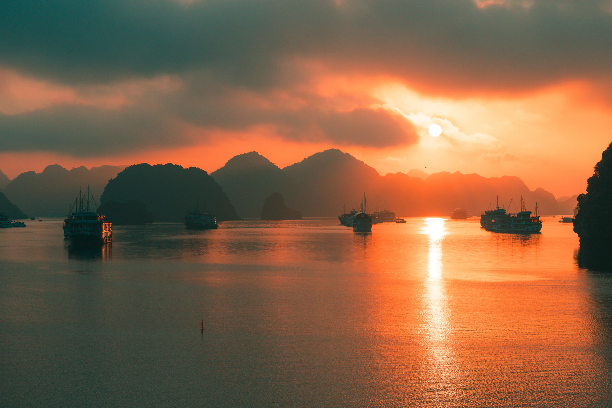 Barcos entre los islotes de la bahía de Ha Long al atardecer