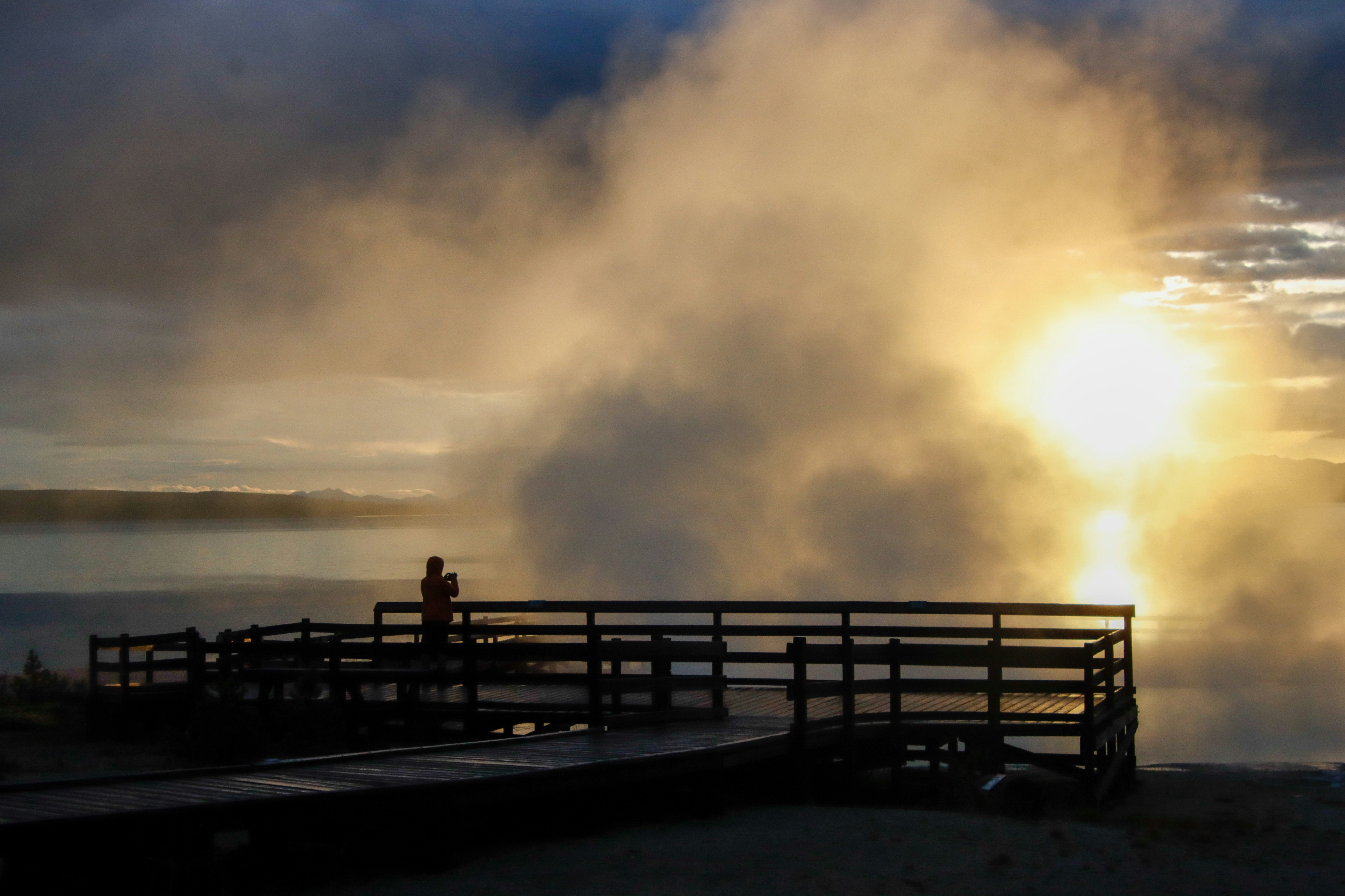 a person standing on a dock near a body of water