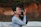 A caring staff member gently holding a pet urn, with a soft background of a serene garden.
