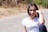 a young girl sitting on the side of a road
