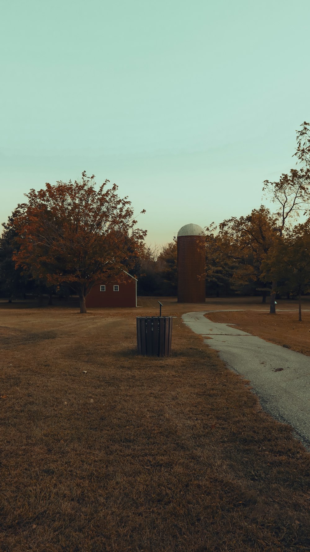 an empty field with a silo in the distance