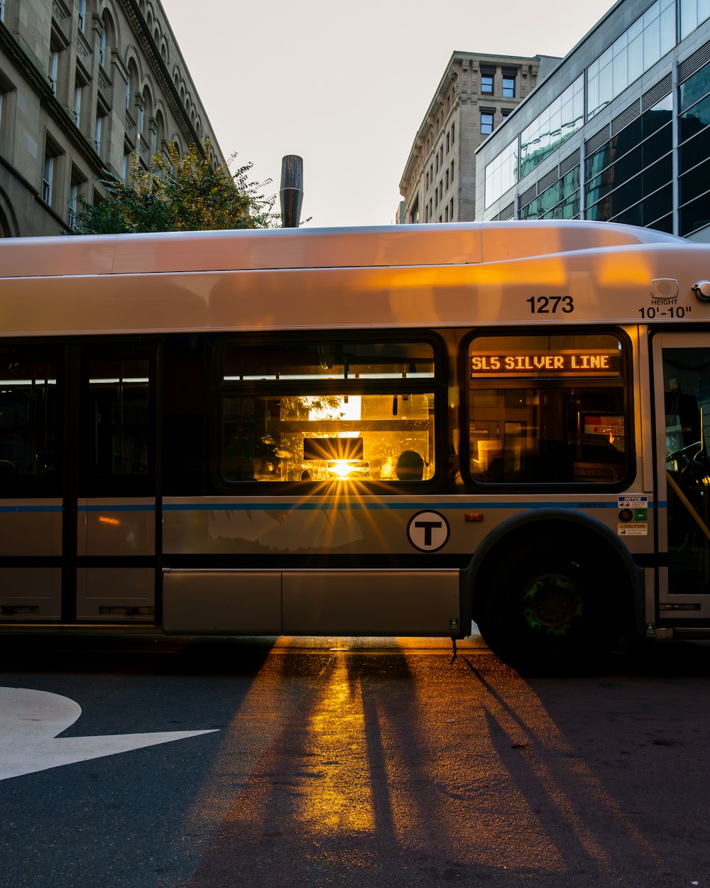 a city bus driving down a street next to tall buildings