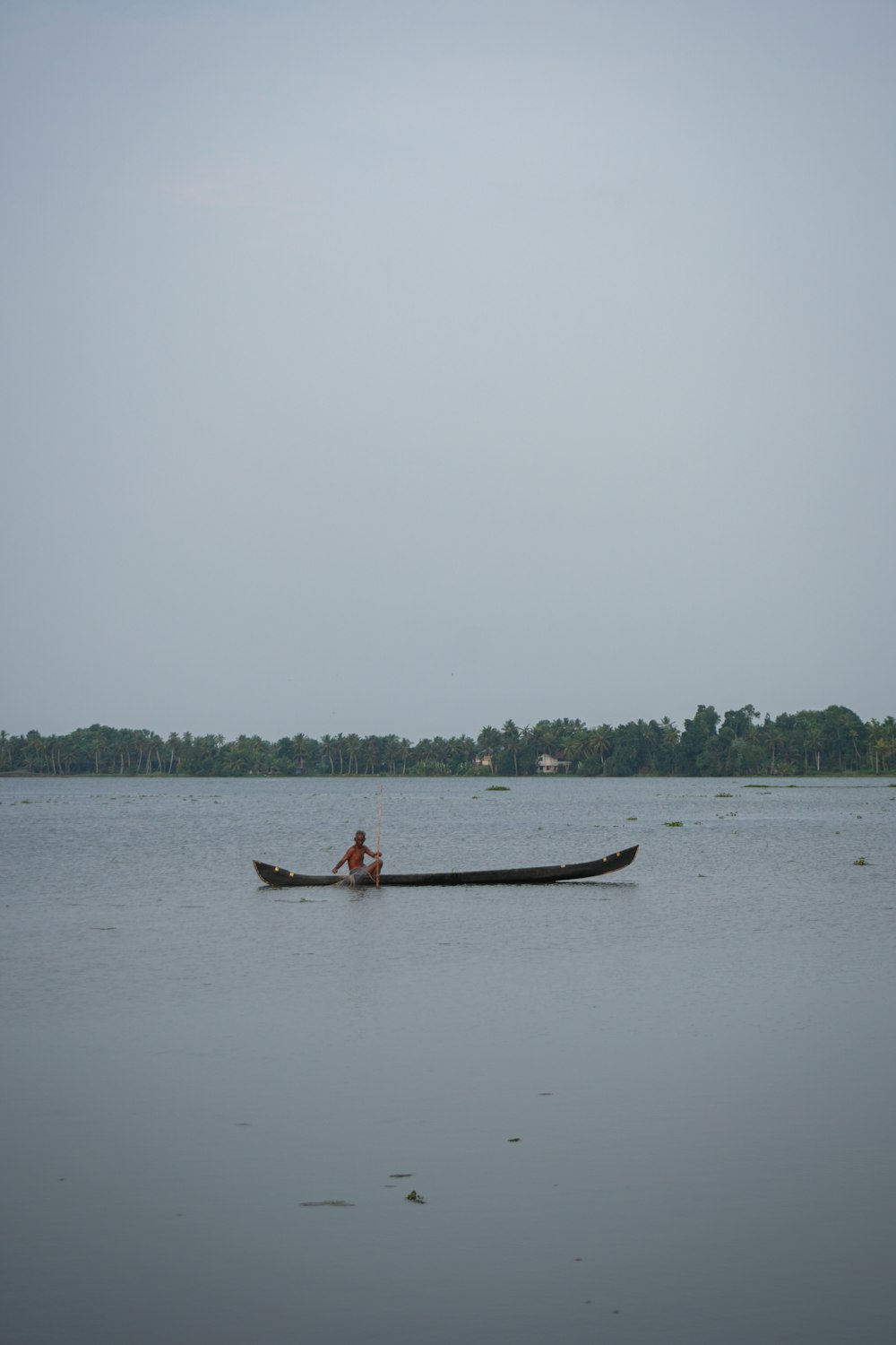 a man in a canoe on a large body of water