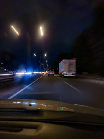 Nighttime view of a limo cruising smoothly on the highway with city lights in the background.
