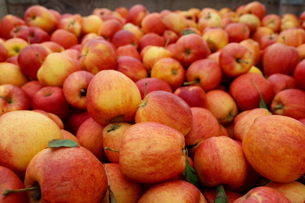 a pile of red apples sitting on top of each other