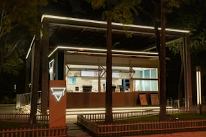 Evening scene of the mobile coffee bar illuminated softly with warm lights, surrounded by greenery