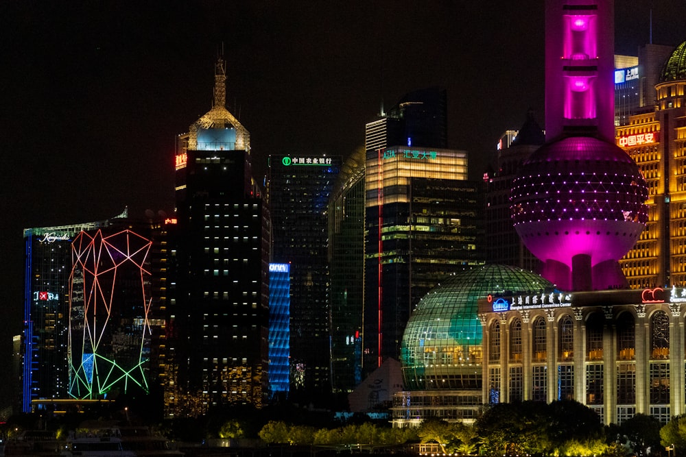 a city skyline with a lot of tall buildings lit up at night