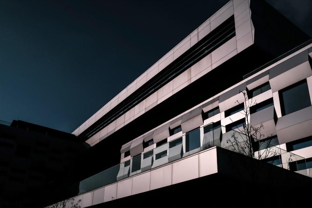 ein Gebäude mit Fenstern und einem Baum davor