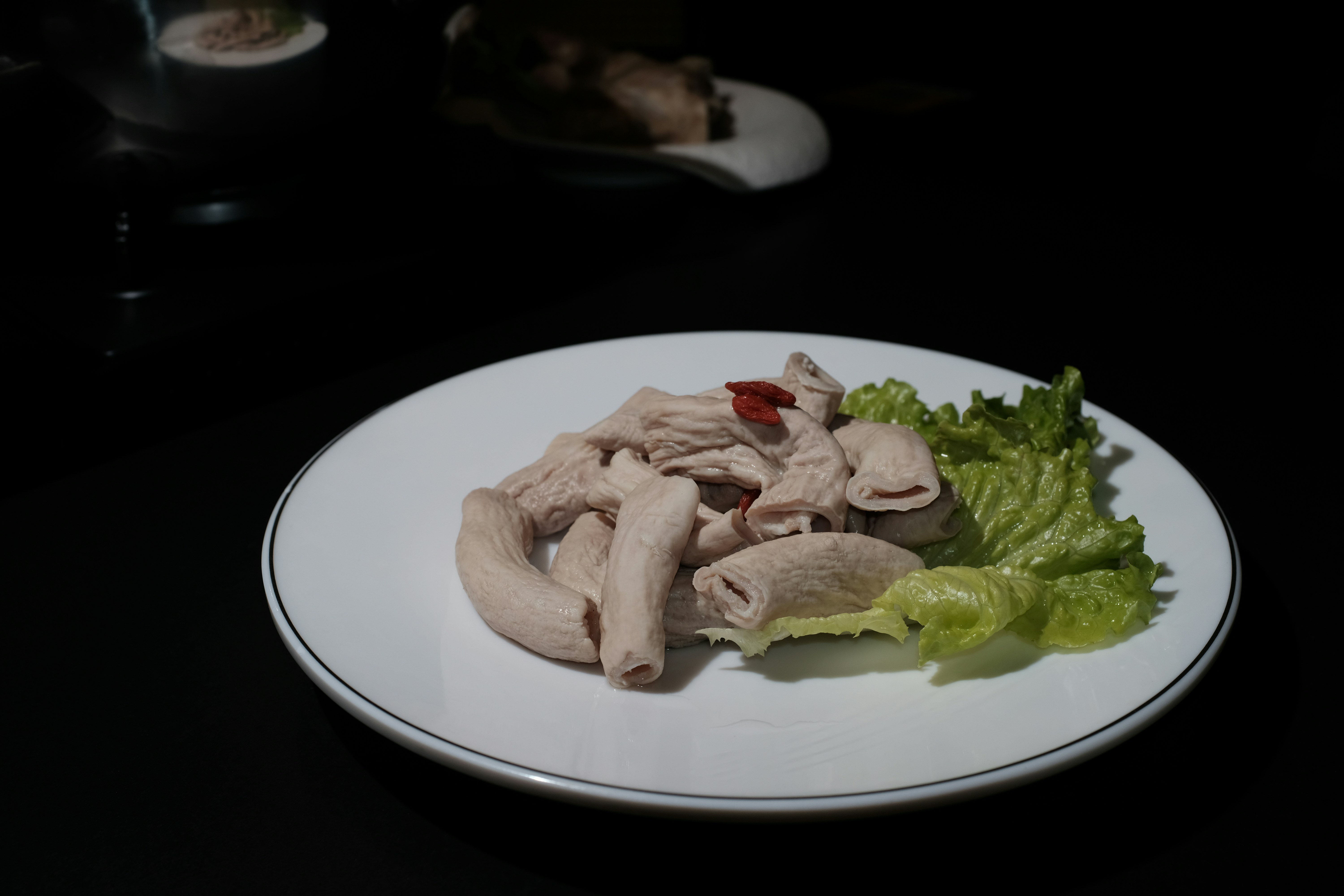 a white plate topped with meat and lettuce