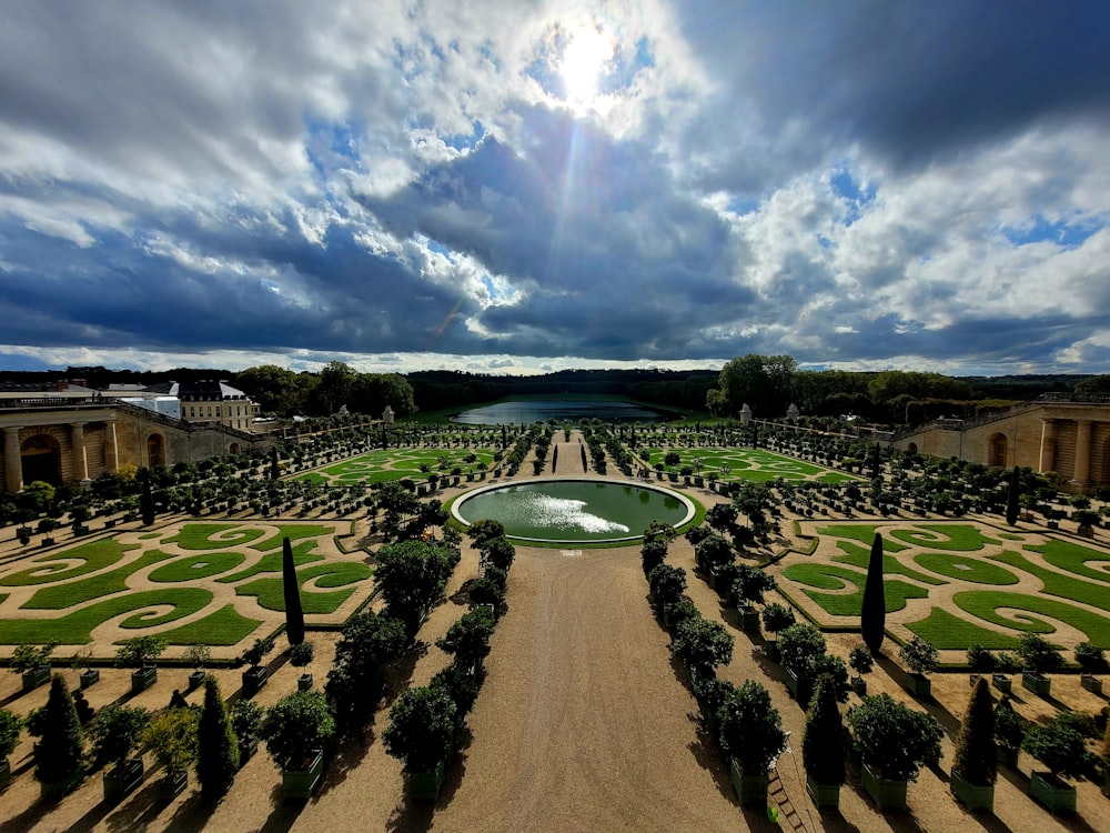 a large garden with a fountain surrounded by trees